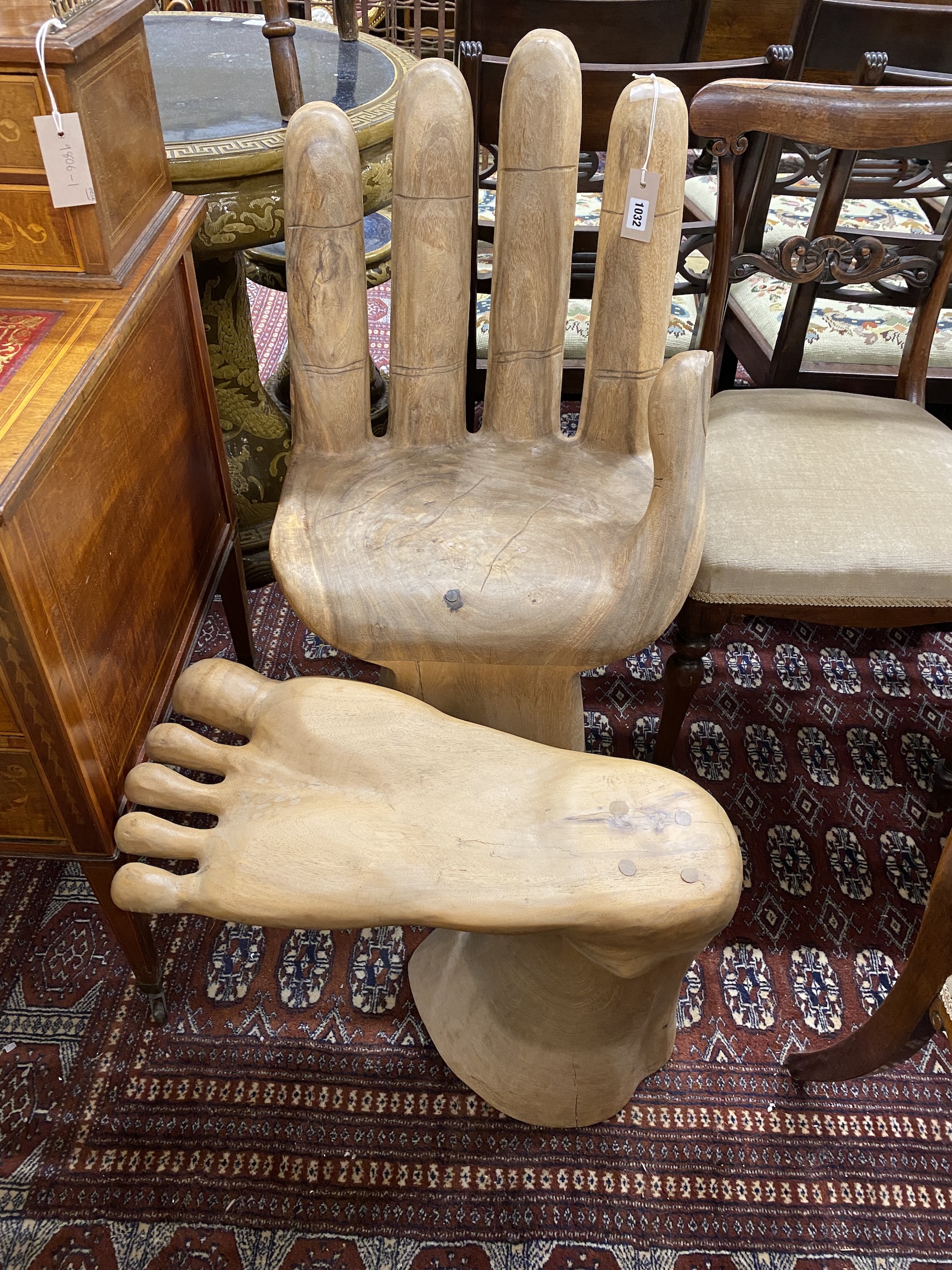 A carved hardwood chair and footstool modelled as a hand and foot, larger height 88cm